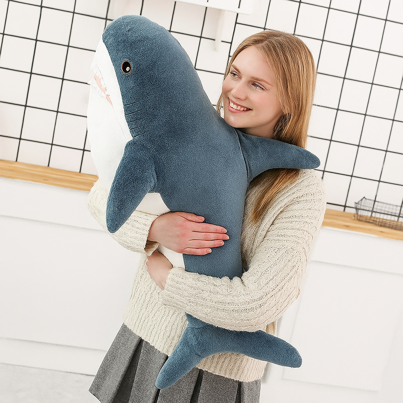 Peluche requin bleu dans les bras d'une fille