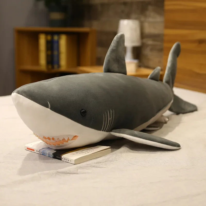 Peluche requin gris XXL sur une table