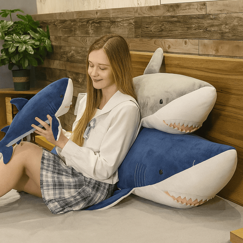 Trois peluches requins XXL sur un lit avec une fille  Image