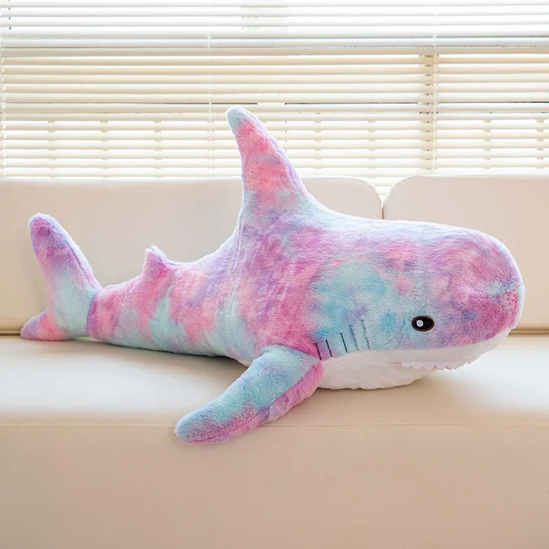 Peluche requin arc-en-ciel sur un canapé