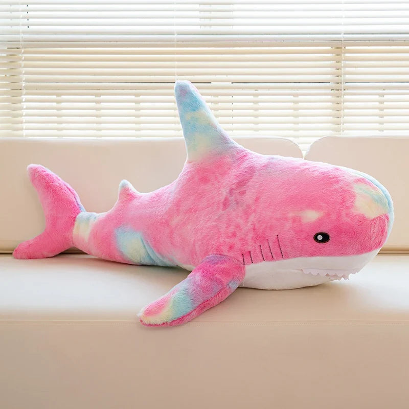 Peluche requin arc-en-ciel sur un canapé