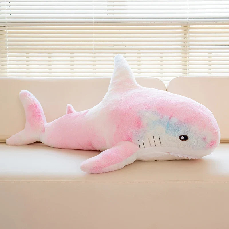 Peluche requin arc-en-ciel sur un canapé