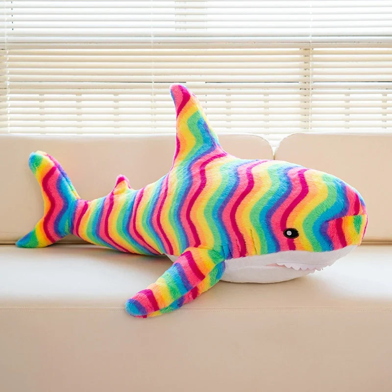 Peluche requin arc-en-ciel sur un canapé