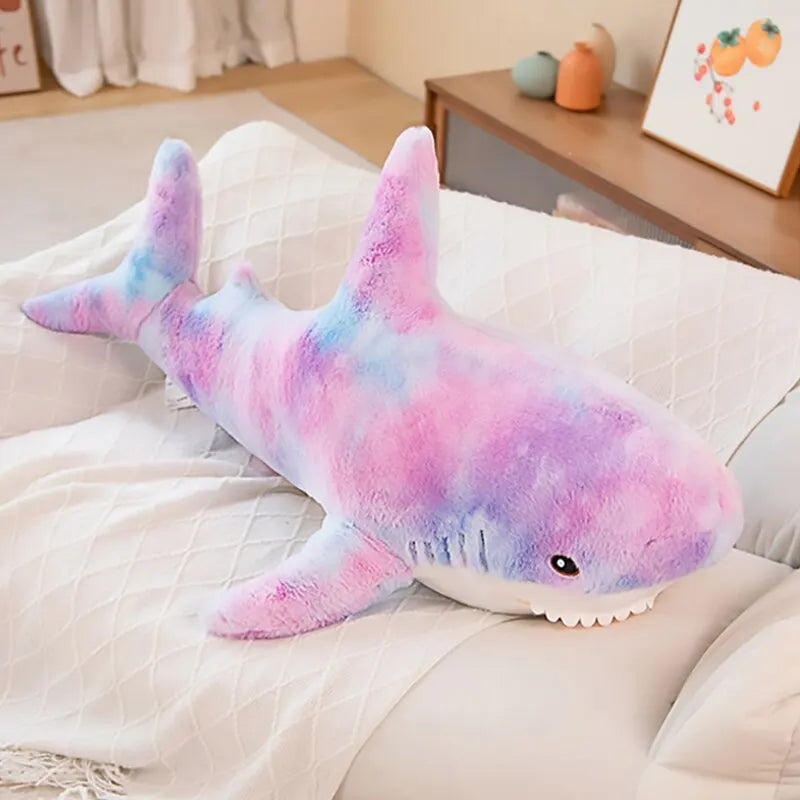 Peluche requin pastel sur un canapé