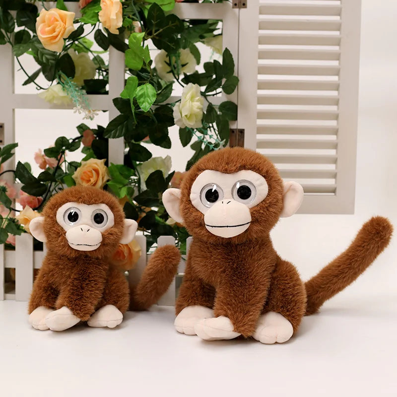 Deux peluches singes aux gros yeux assis devant une fenêtre avec des fleurs Image