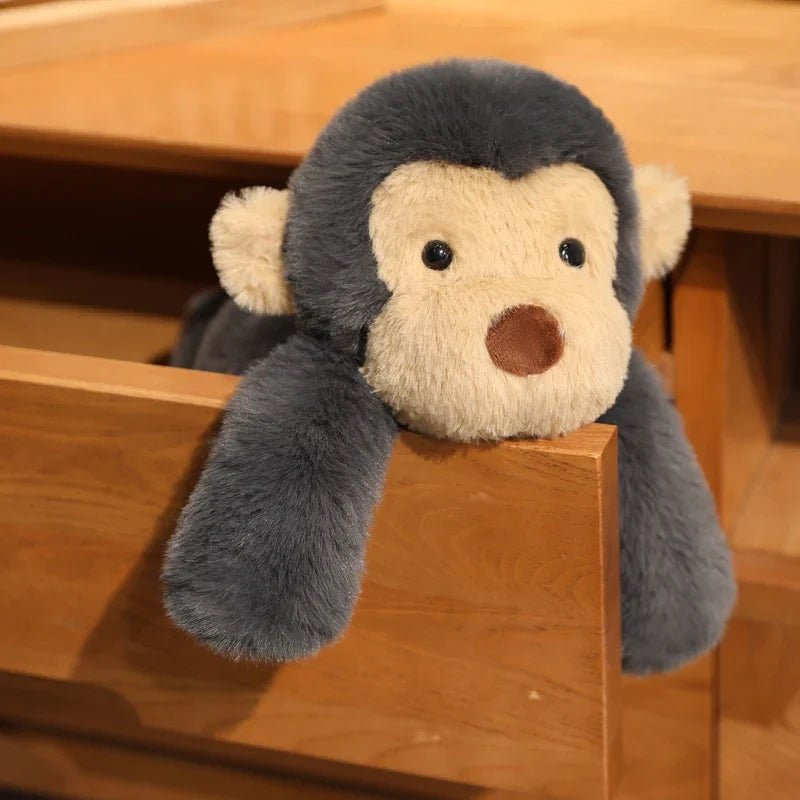 Peluche singe noir douce couché dans un tiroir d'un meuble Image