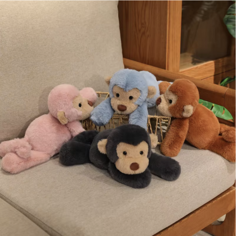 Quatre peluches singes douces couchés sur panier en osier étant posés sur un fauteuil Image