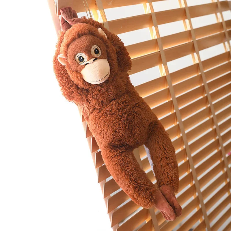 Peluche singe orang-outan accroché sur un store en bois Image