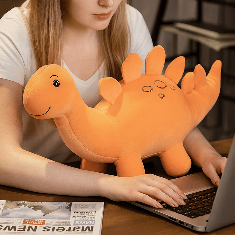 Peluche stégosaure orange sur une table avec une fille derrière Image