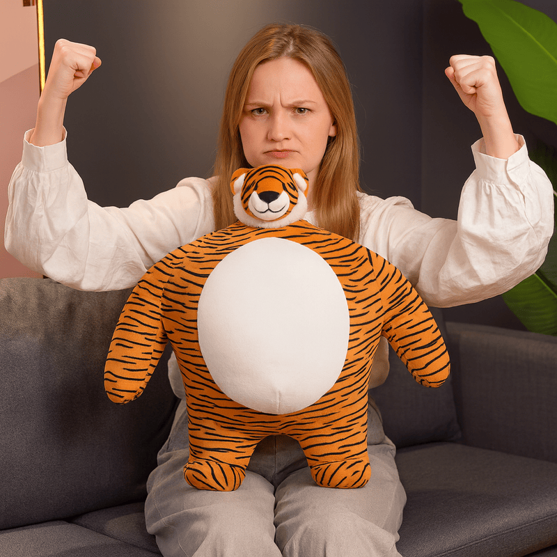 Peluche tigre super-héros sur une les genoux d'une fille assise sur un canapé Image