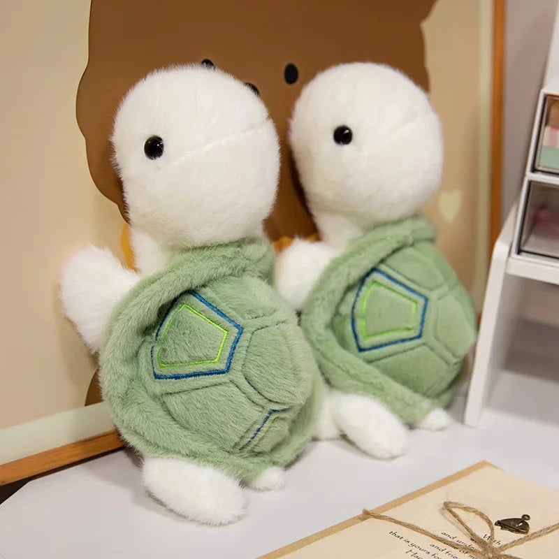 Deux peluches tortues blanches contre un mur