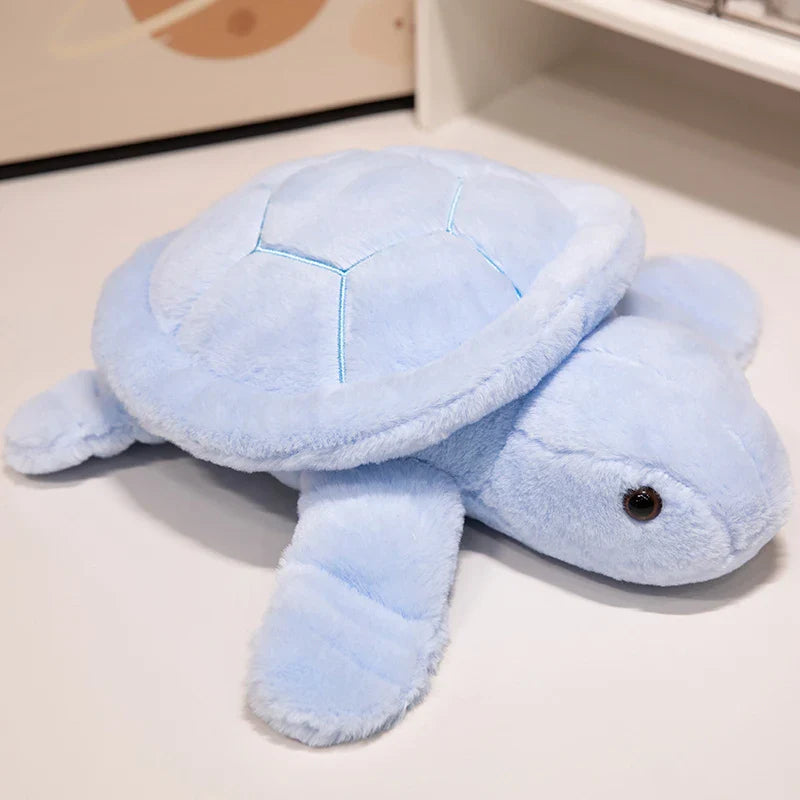 Peluche tortue colorée bleue sur un meuble blanc