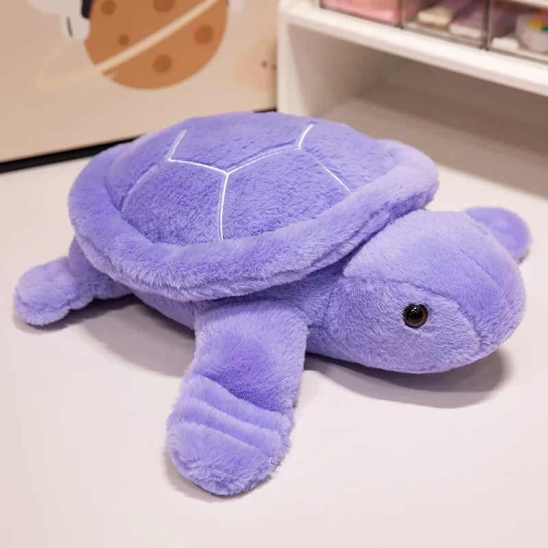 Peluche tortue colorée violet sur un meuble blanc