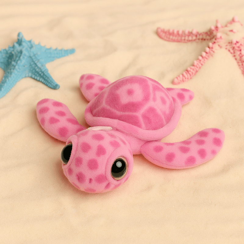 Peluche tortue mignonne rose sur du sable fin 