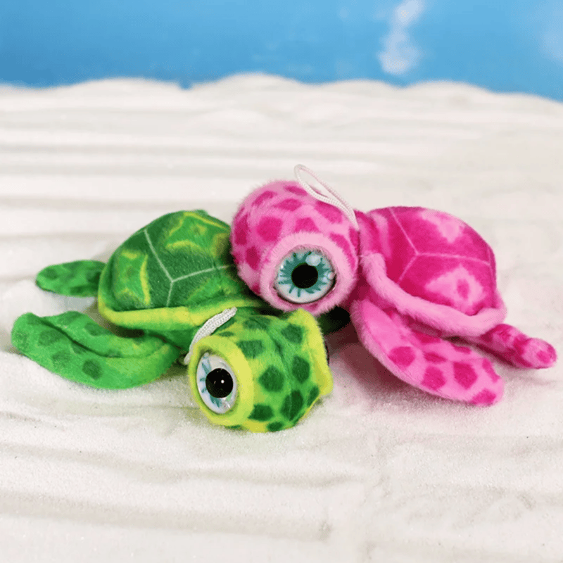 Deux peluches tortues mignonne l'une contre l'autre sur du sable fin Image