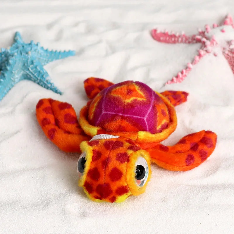 Peluche tortue mignonne rouge sur du sable fin