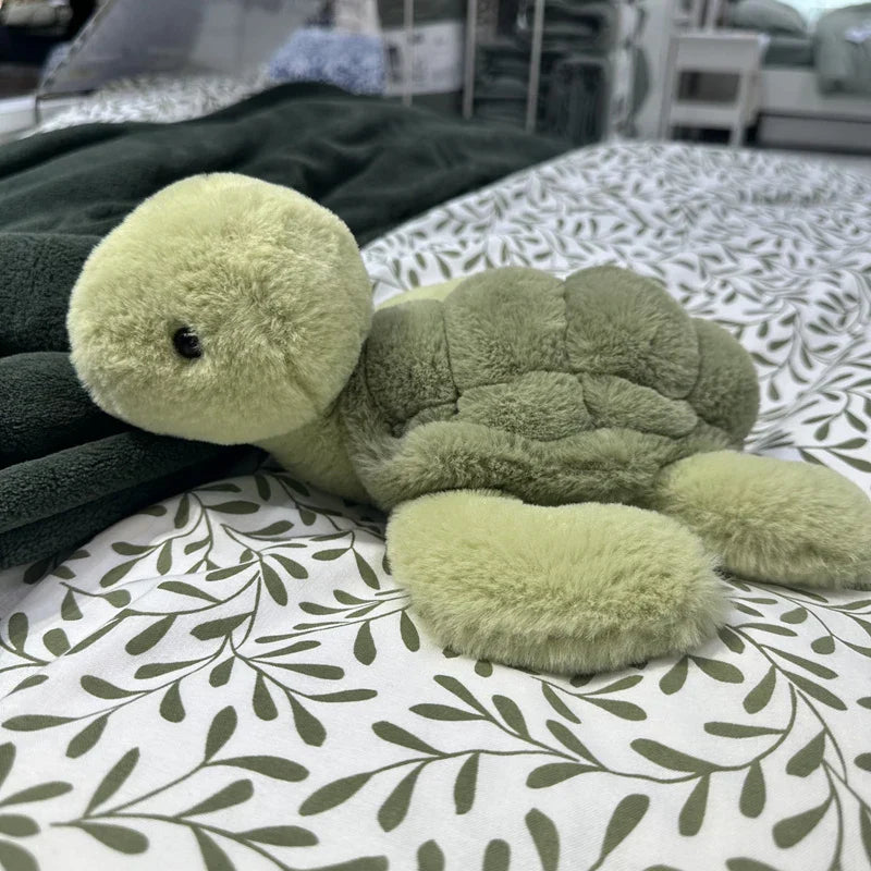 Peluche tortue réaliste sur un lit 