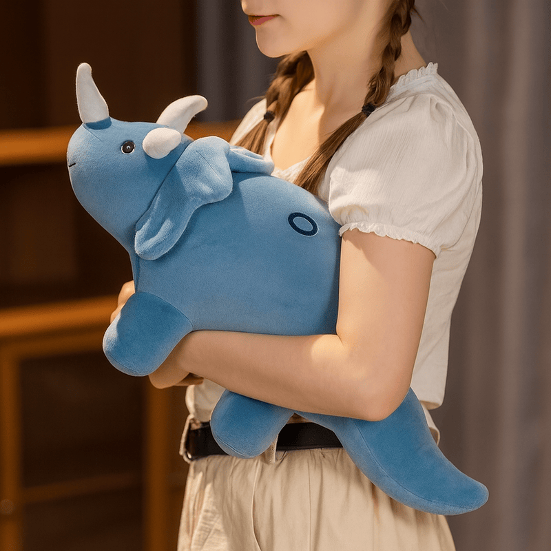Peluche triceratops bleue dans les bras d'une fille Image