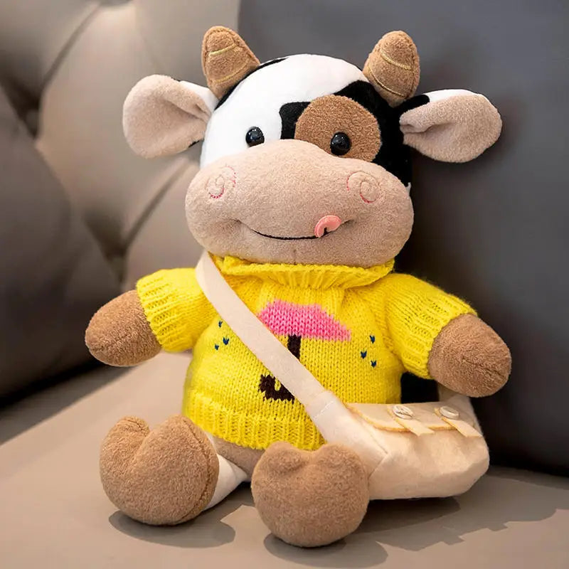 Peluche vache avec son col roulé jaune sur un canapé