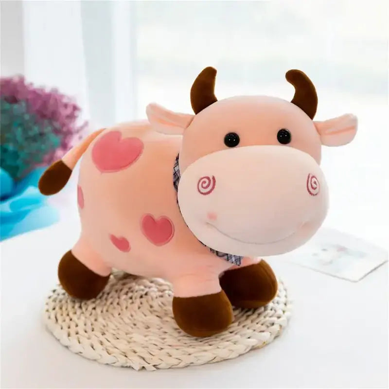 Peluche vache cartoon rose sur une table