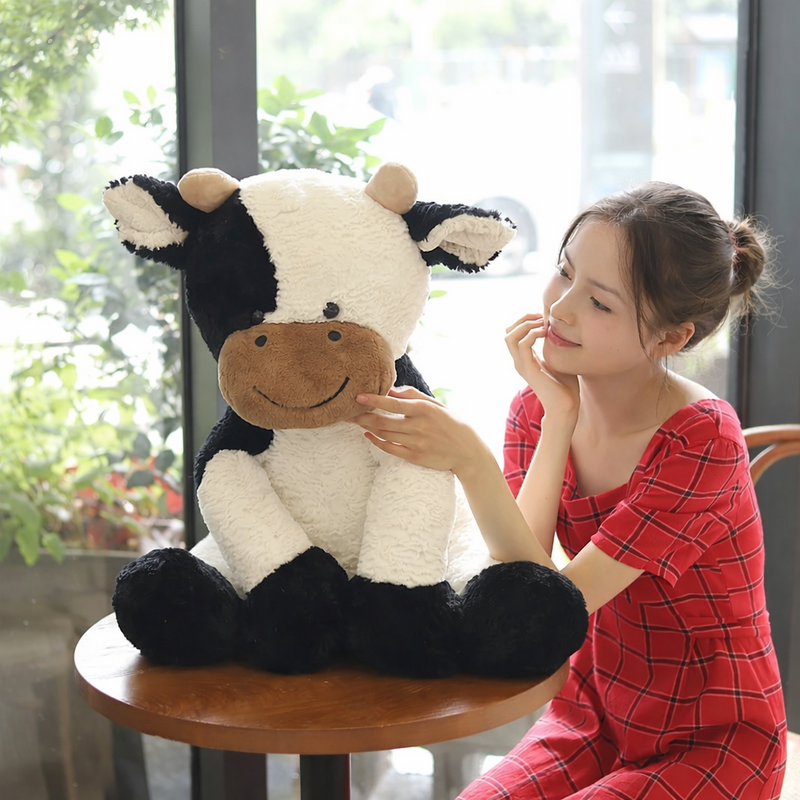 Peluche vache kawaii sur une table ronde avec une fille à côter