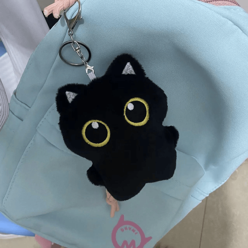 Petit chat noir en peluche accrocher sur un sac 