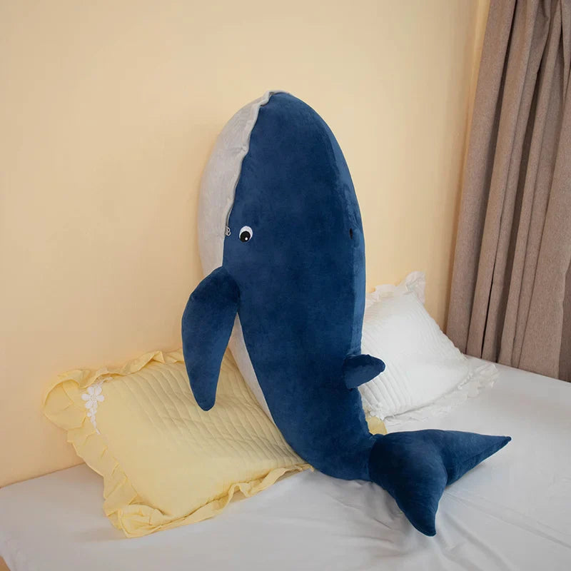 Peluche baleine bleue nordique poser sur un lit 