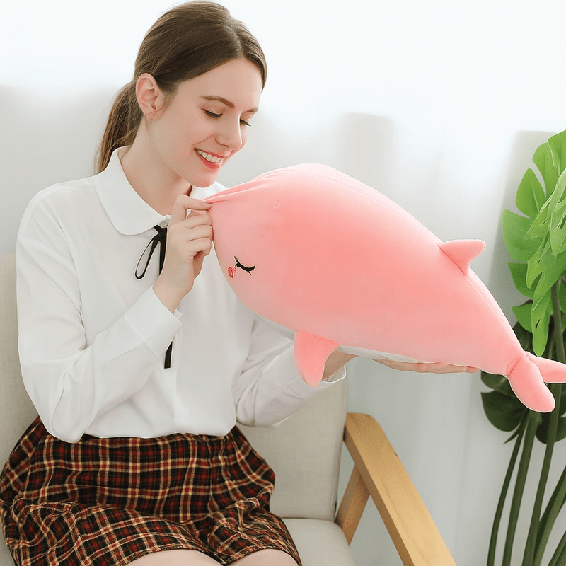 Peluche baleine rose dans les mains d'une femme 