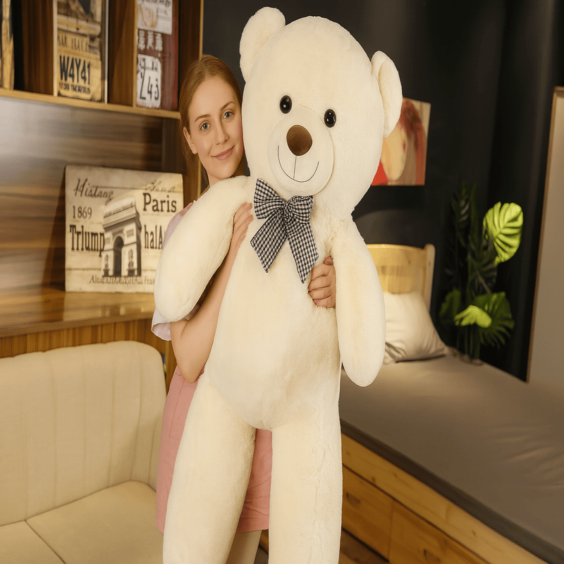ours blanc en peluche géante avec noeud papillon dans les bras d'une fille