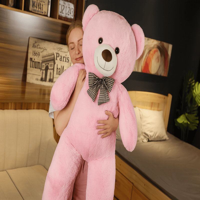 ours rose en peluche géante avec noeud papillon dans les bras d'une fille