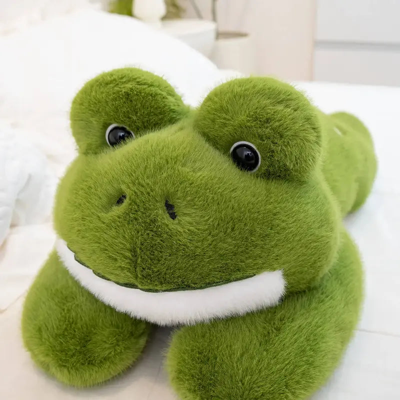 peluche grenouille oreiller sur un lit blanc Image